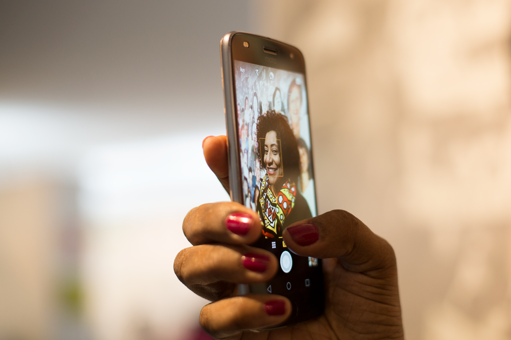 Descrição da Imagem: Eliana Filinto tirando uma selfie com o seu smartphone da Motorola, o modelo moto z2 play.