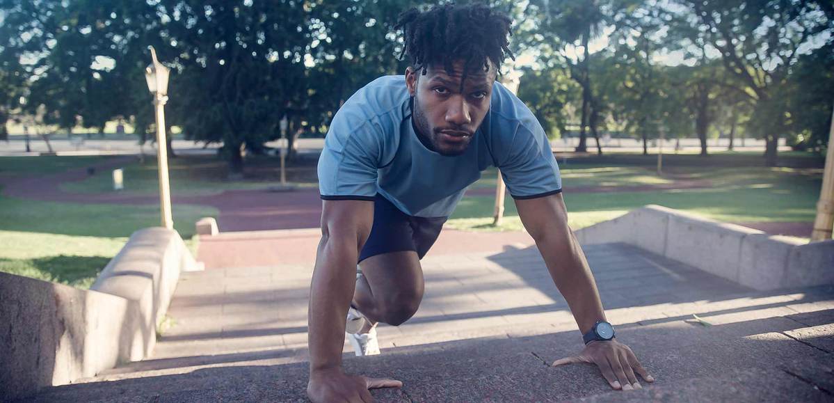 homem em um parque em posição de corrida